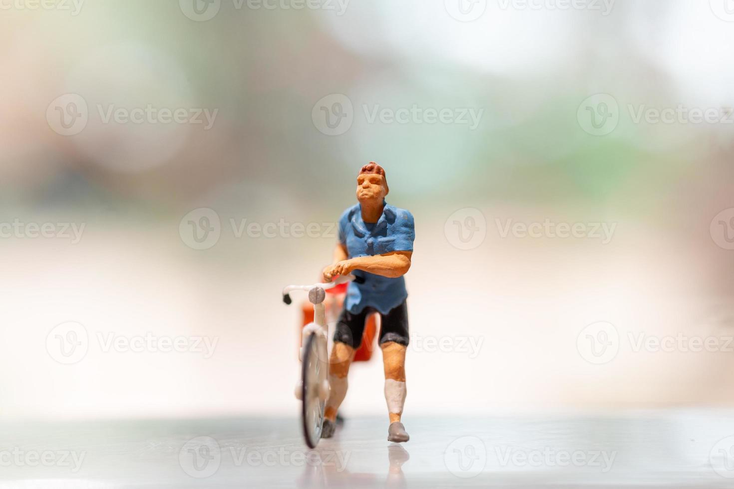 Miniature cyclist standing with bike, World bicycle day concept photo