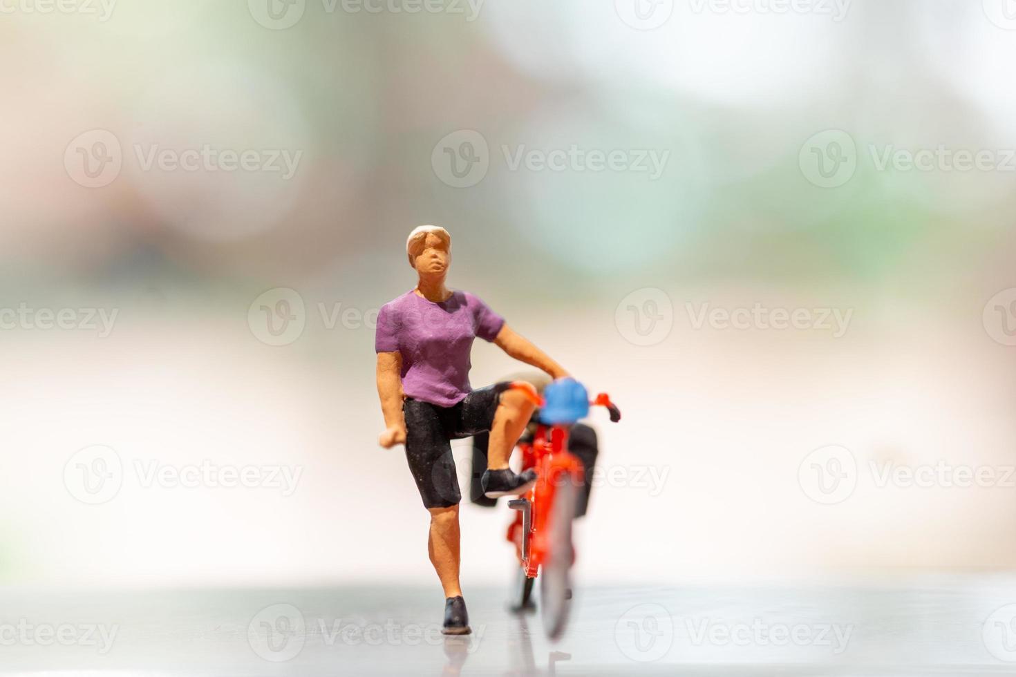 Miniature cyclist standing with bike, World bicycle day concept photo