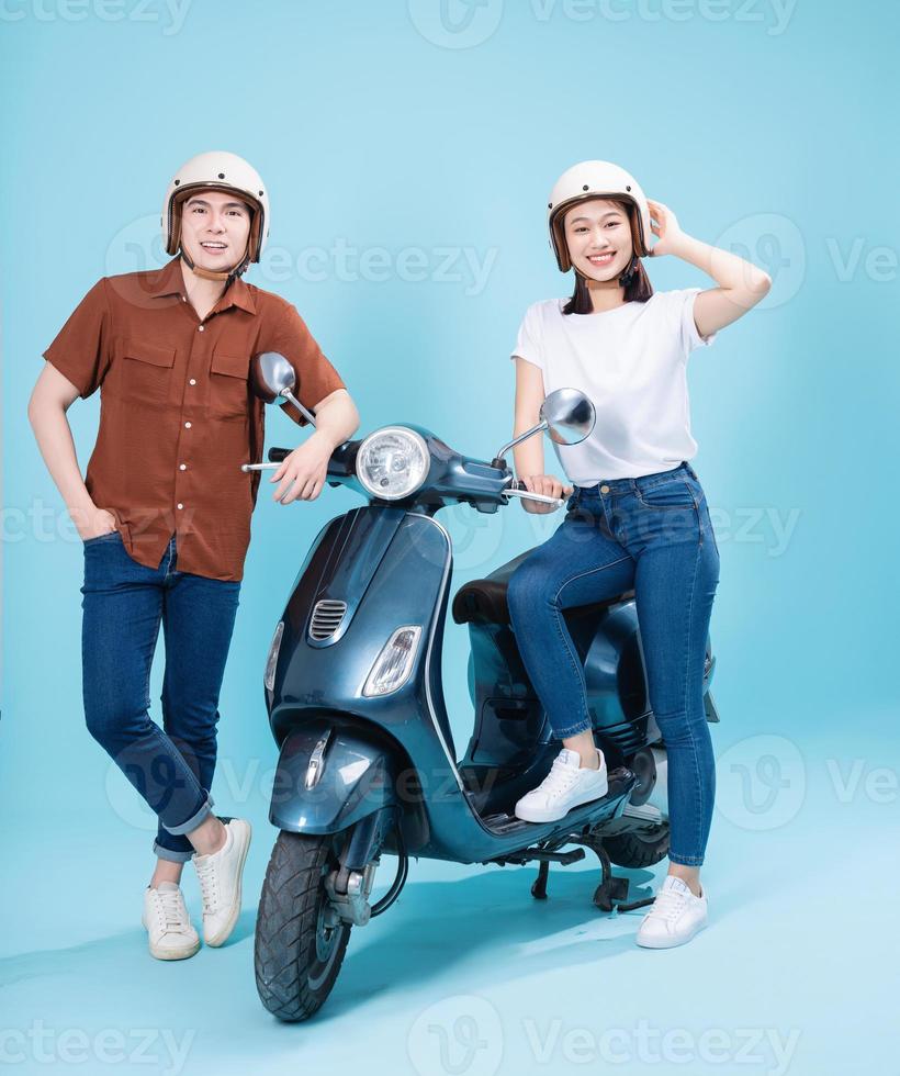 Young Asian couple ride scooter on background photo