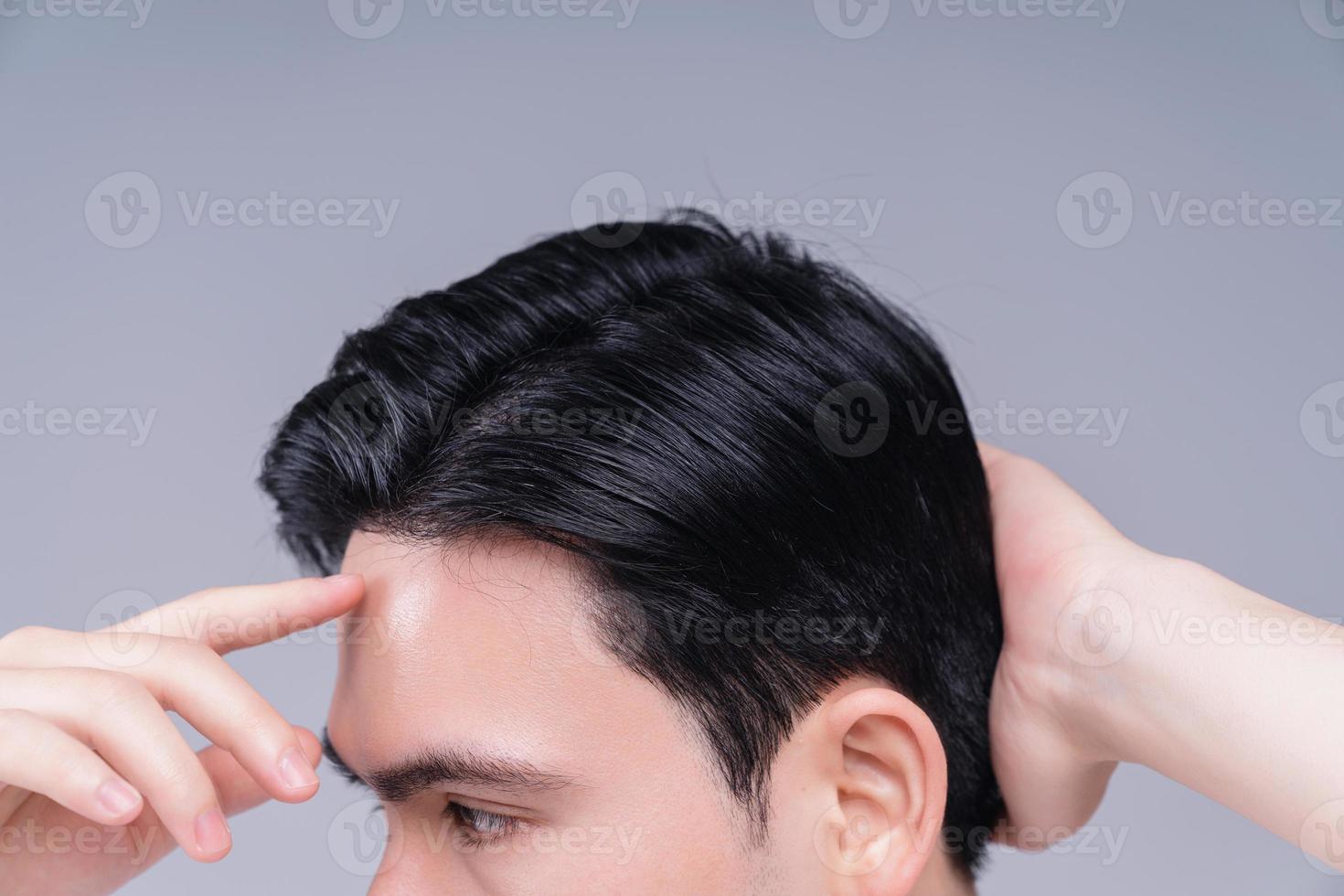 Image of young Asian man hair care on background photo