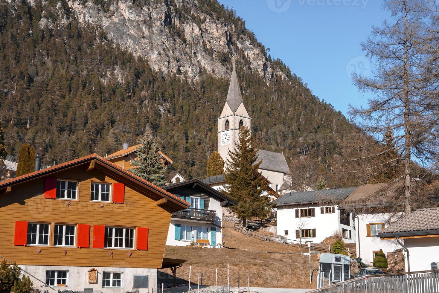 Church and houses with majestic mountain in background photo