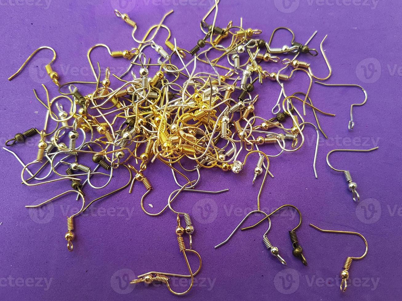 A lot of laid out schwenz hooks on a purple background Earring accessory Materials for creating jewelry photo