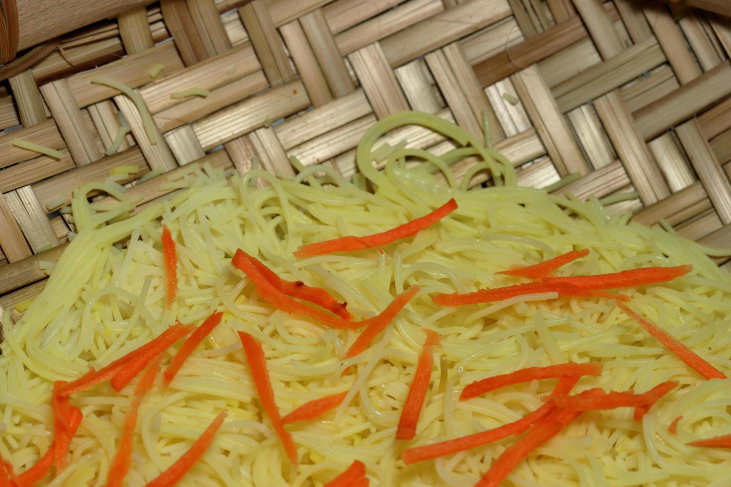 Simple chicken chow mein meal on a white plate and on a wooden table. Chinese stye tasty noodels with sauce and vegitables. photo