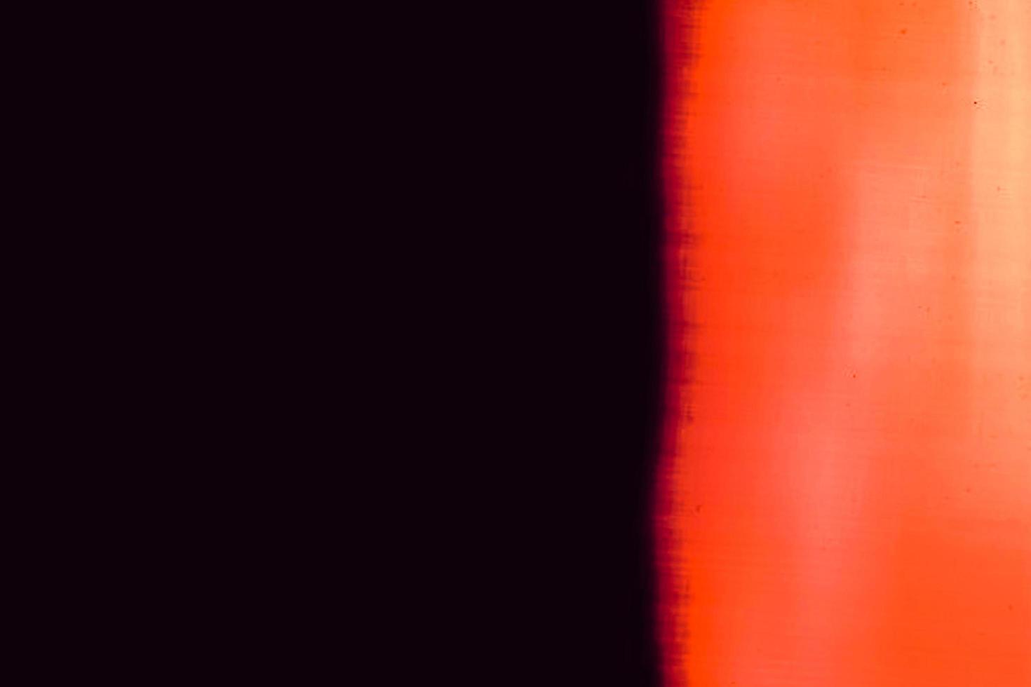Blank grained and scratched film strip texture background with heavy grain, dust and a light leak Real Lens Flare Shot in Studio over Black Background photo