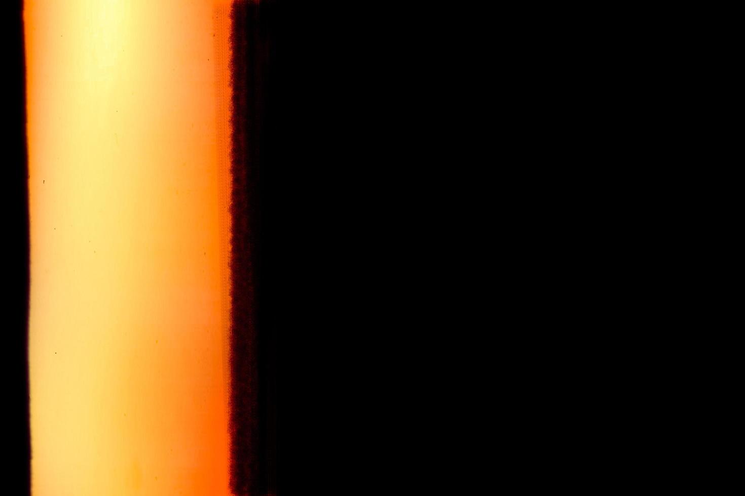 Blank grained and scratched film strip texture background with heavy grain, dust and a light leak Real Lens Flare Shot in Studio over Black Background photo