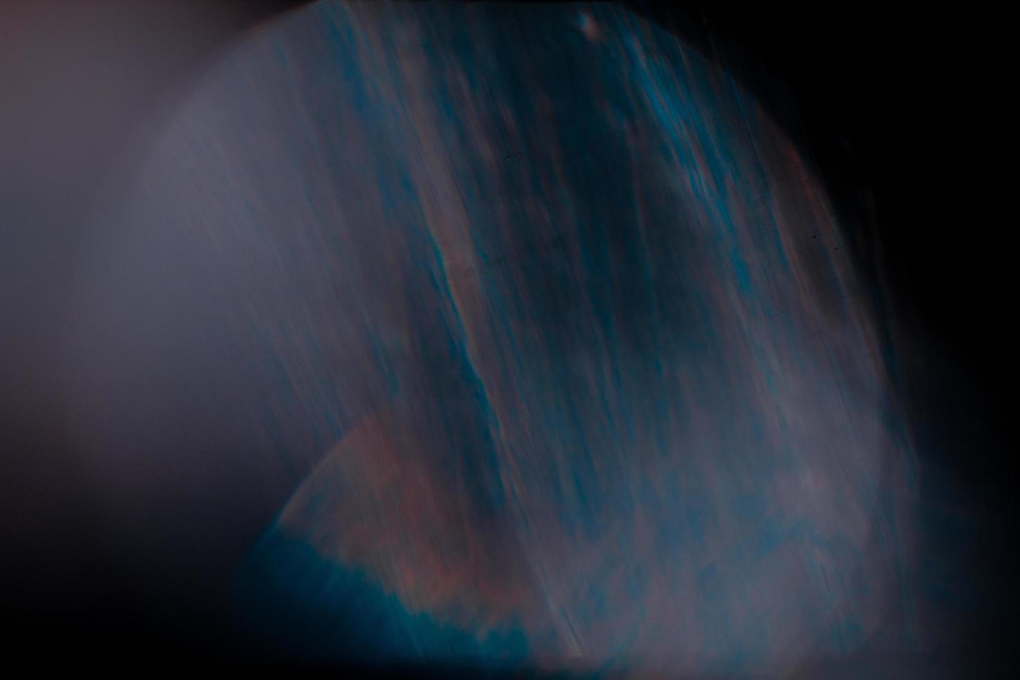 Lens flare and light leak haze texture on a black background. photo