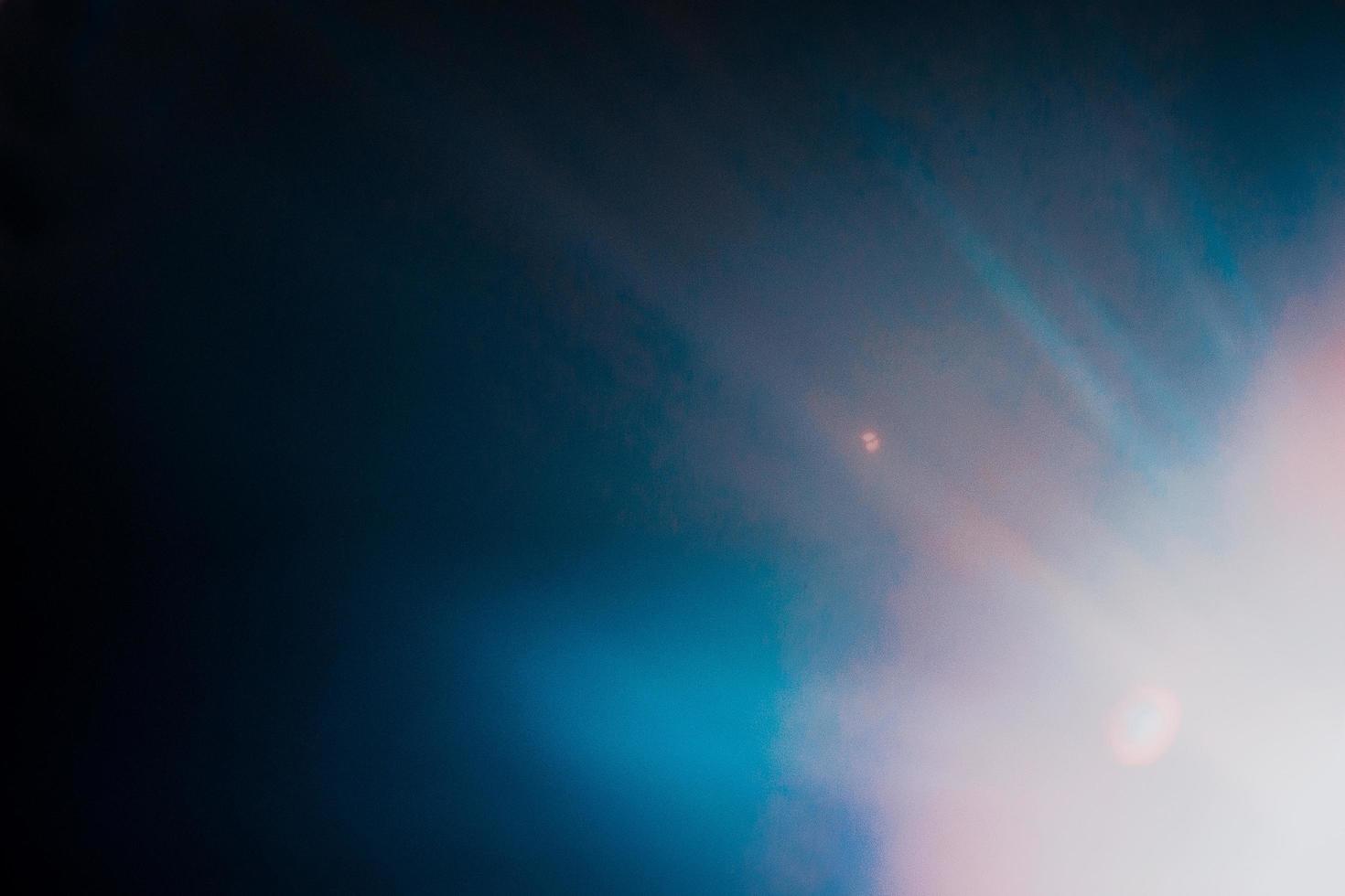 Lens flare and light leak haze texture on a black background. photo