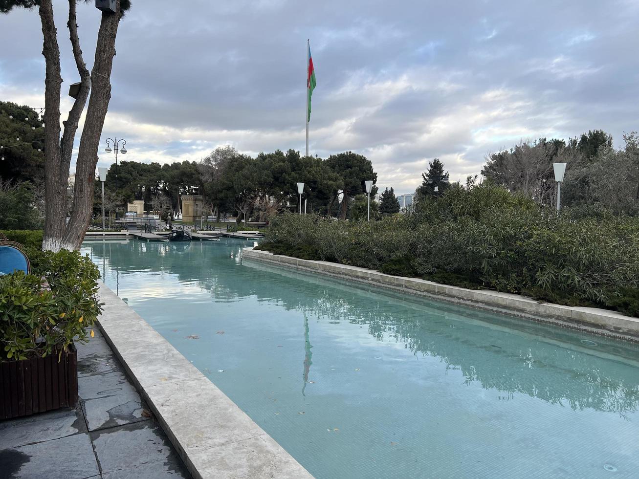 park with pool and azerbaijan flag waving in cloudy weather photo