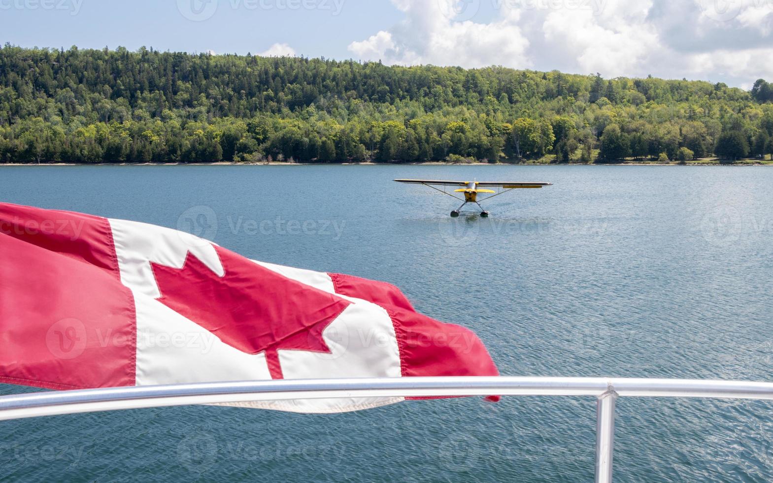 Canadian flag and a yellow sea plane on Georgian Bay in Canada photo