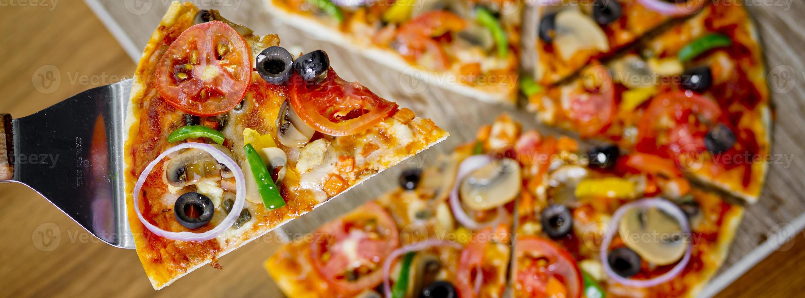 Popular colorful ingredients as like tomatoes, cheese, mushroom, capsicum, olives and other ingredients baked healthy Pizza. photo