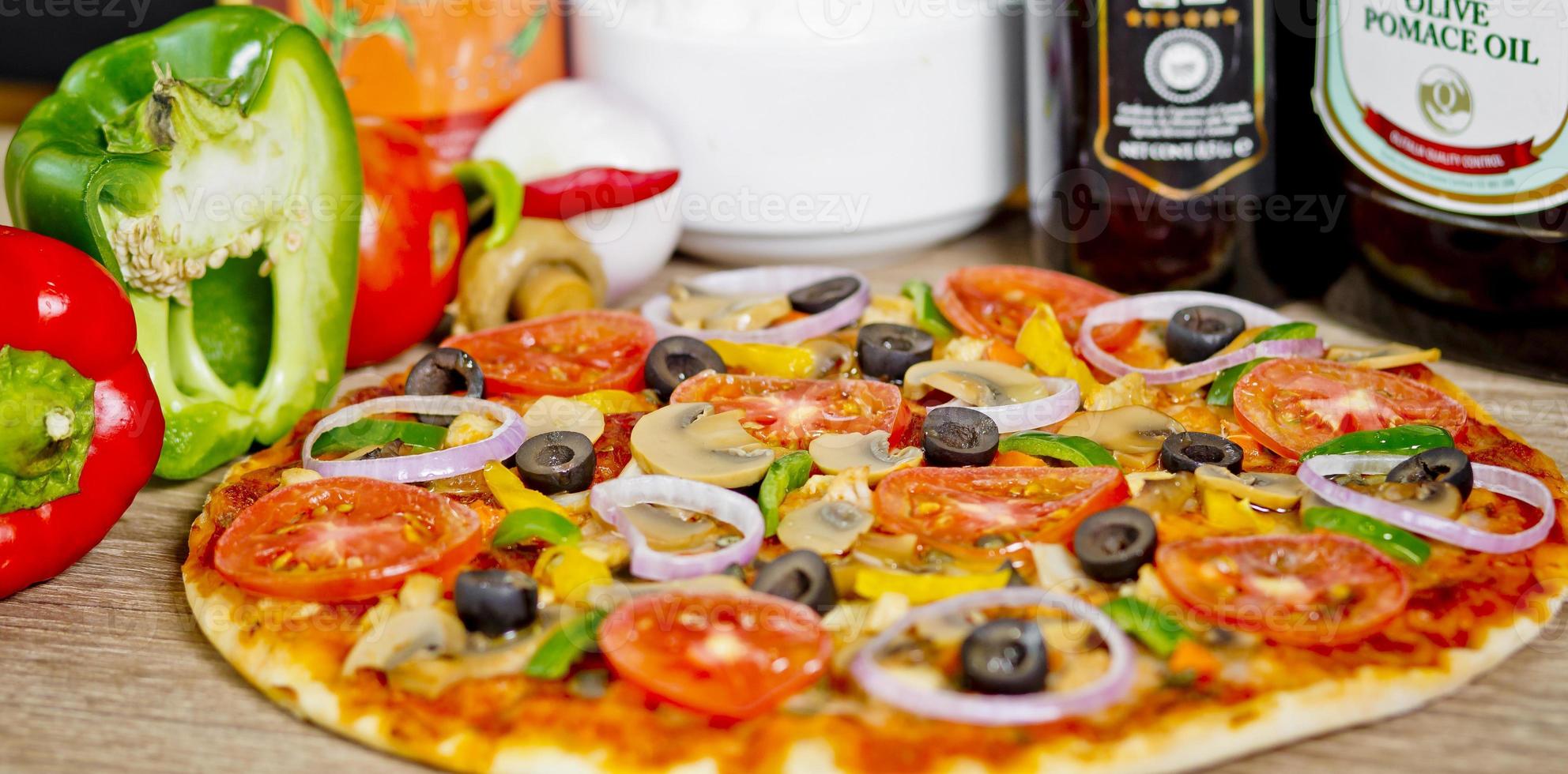 Popular colorful ingredients as like tomatoes, cheese, mushroom, capsicum, olives and other ingredients baked healthy Pizza. photo