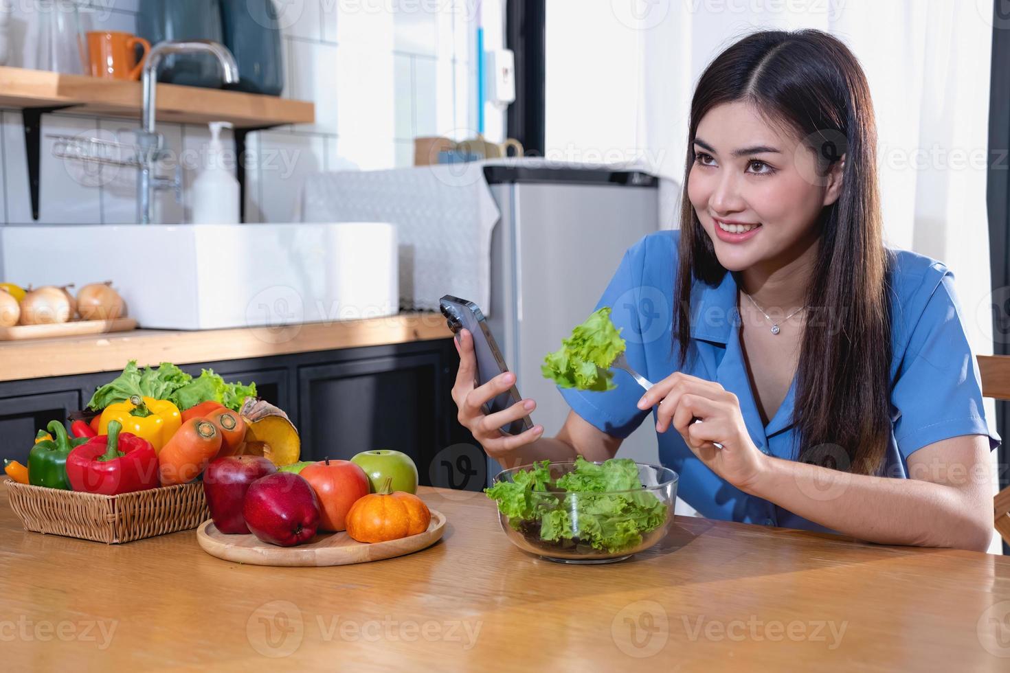 dieta, De piel blanca joven asiático mujer en un azul camisa comiendo vegetal ensalada y manzanas como un sano dieta, optando para basura alimento. hembra nutricionista perdiendo peso. sano comiendo concepto. foto