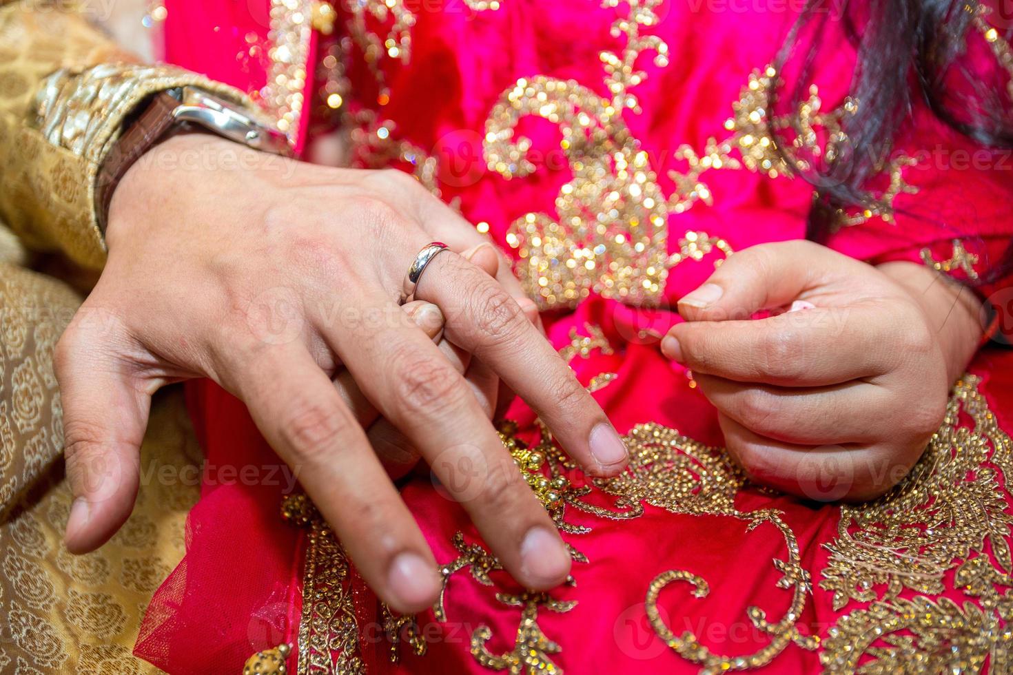 Groom places the wedding ring on the Brides finger at Bangladesh. Close up image. photo