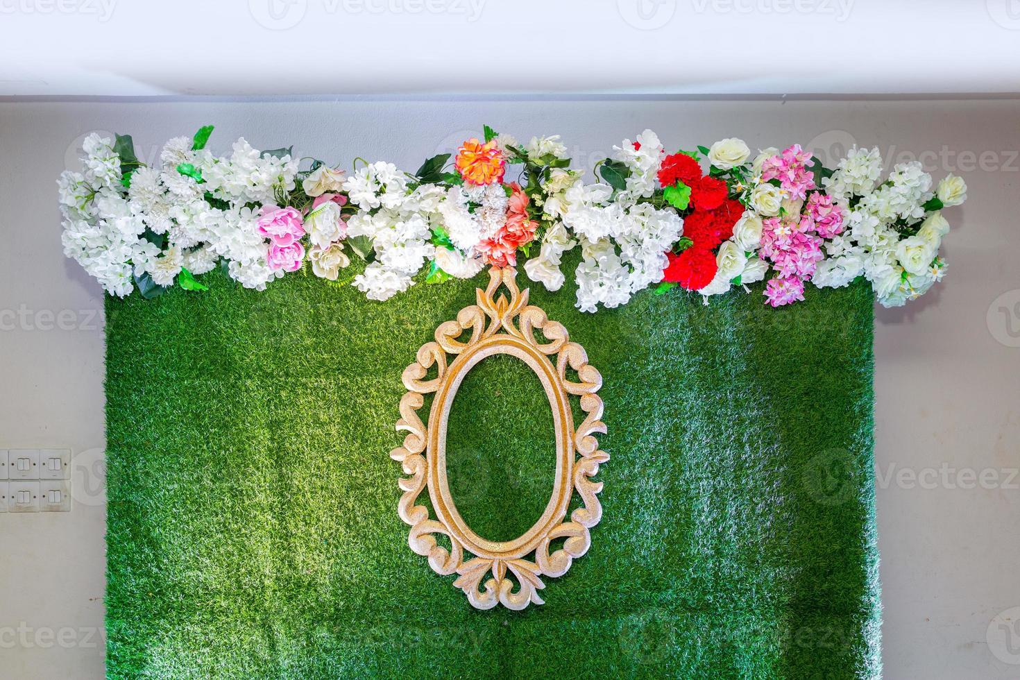 Green artificial grass based wedding stage with artificial colorful paper flower decoration. photo