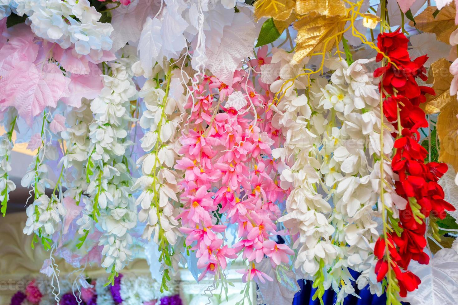 vistoso artificial papel flores colgando en un escenario. Boda decoración. el plastico vistoso decorado flor. foto