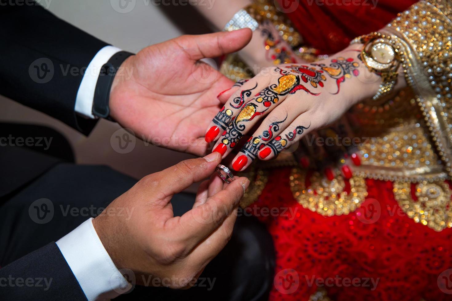 A groom puts the ring on the finger of bride. Indian Wedding. photo