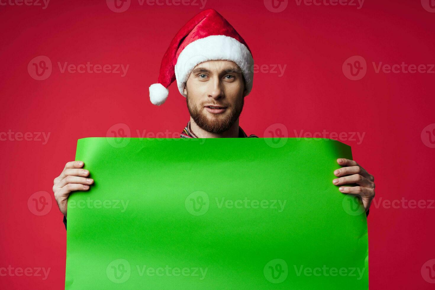 handsome man in a christmas hat with green mockup studio posing photo