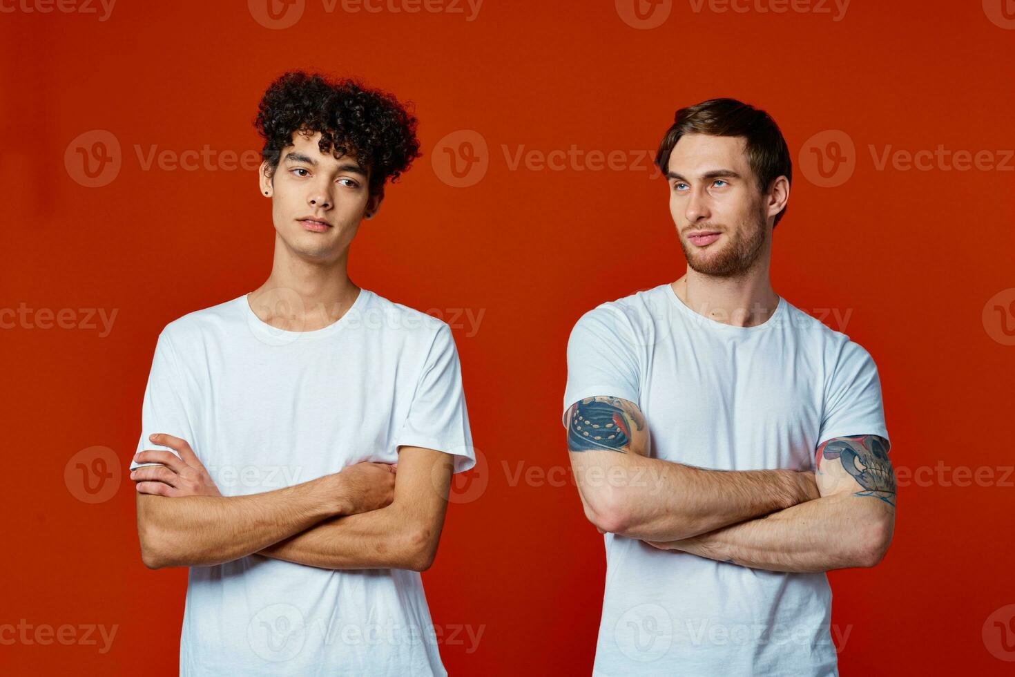 two friends in white t-shirts construction teams he emotions red background photo