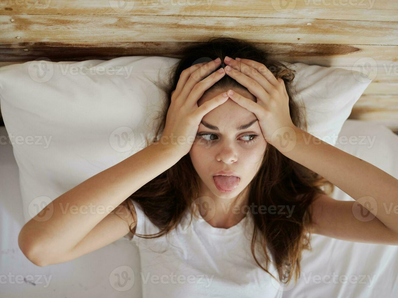 mujer participación su cabeza en cama demostración lengua parte superior ver foto