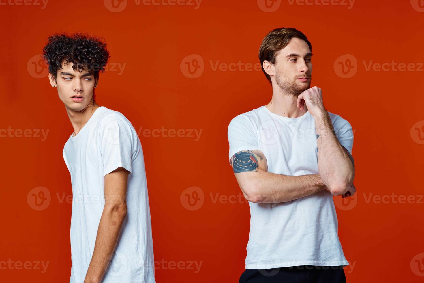 Two friends in white t-shirts emotions communication lifestyle red background photo