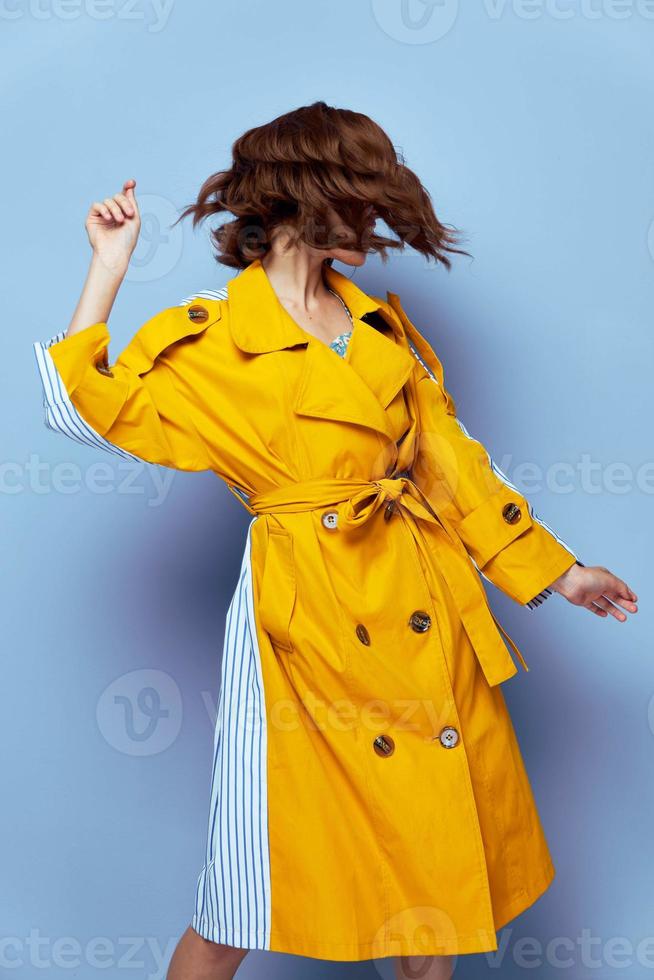 Woman looking to the side short hairstyle covers the fac yellow coat photo