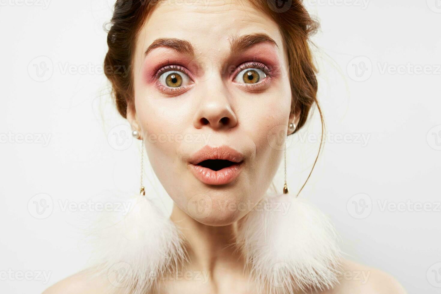 woman with fluffy earrings bright makeup emotions close-up photo