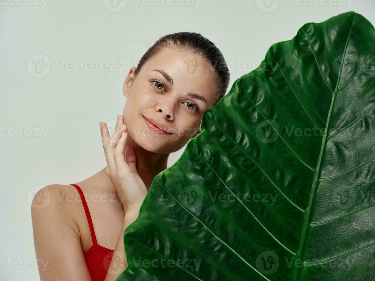 young woman clean skin green palm leaf natural look cosmetology photo