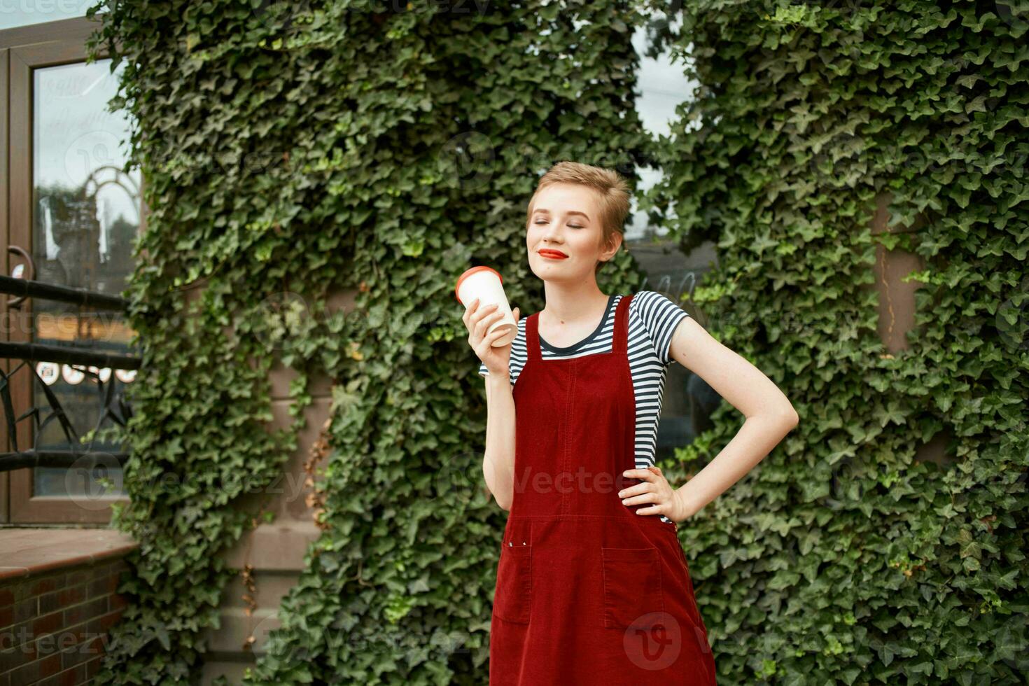 short haired woman outdoors a cup of drink lifestyle shrubs photo