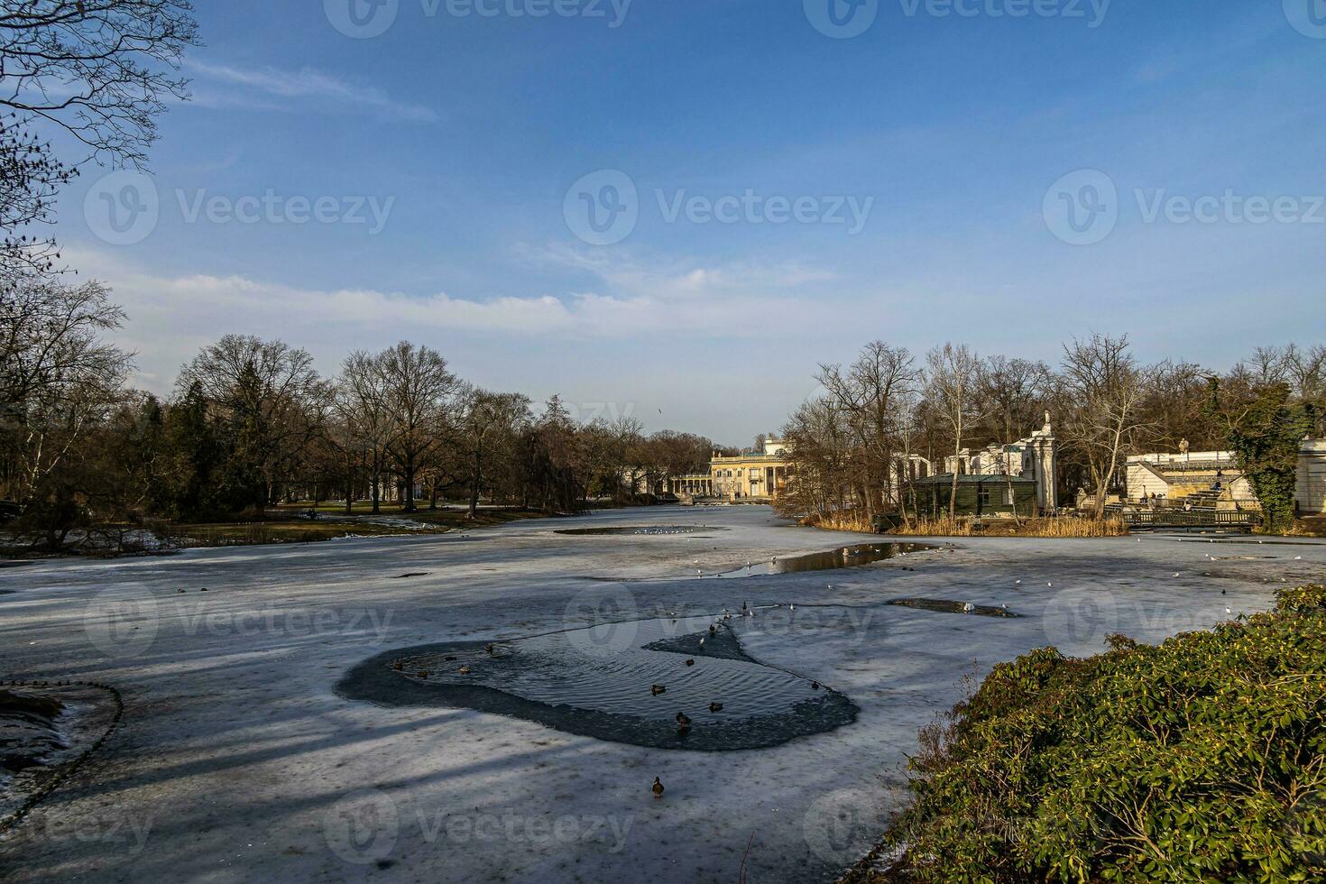 landscape with a palace on the water in Warsaw, Poland early spring on a sunny day with melting snow photo