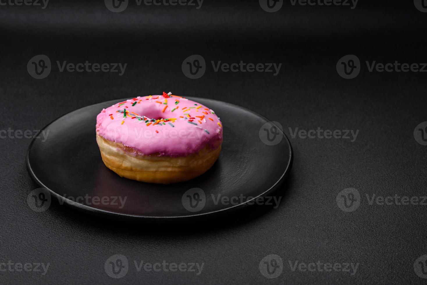 Delicious donut with cream filling and nuts on a dark concrete background photo