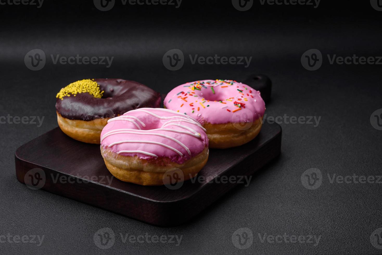 Delicious donut with cream filling and nuts on a dark concrete background photo