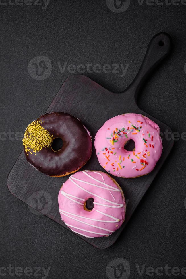 Delicious donut with cream filling and nuts on a dark concrete background photo