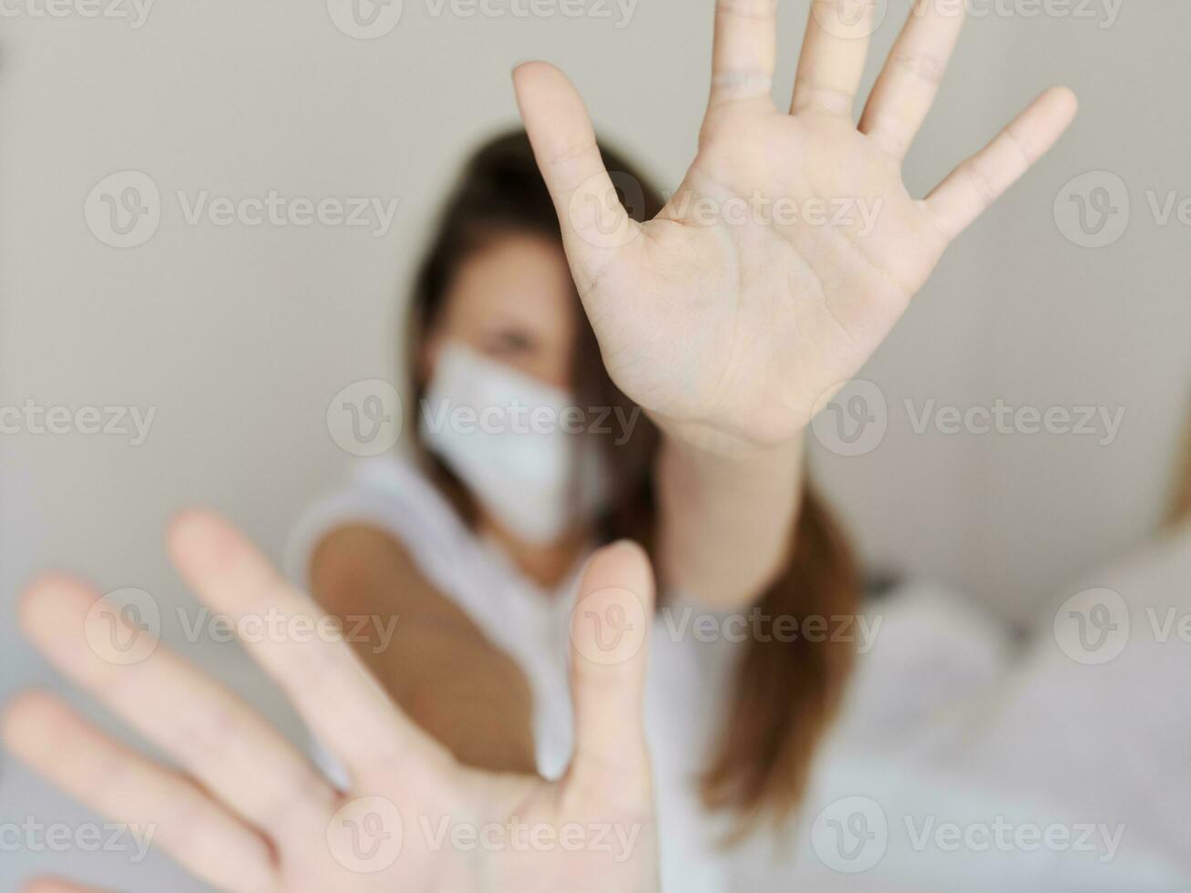 emotional woman in medical mask covers her face with hands aggression irritability pandemic quarantine photo