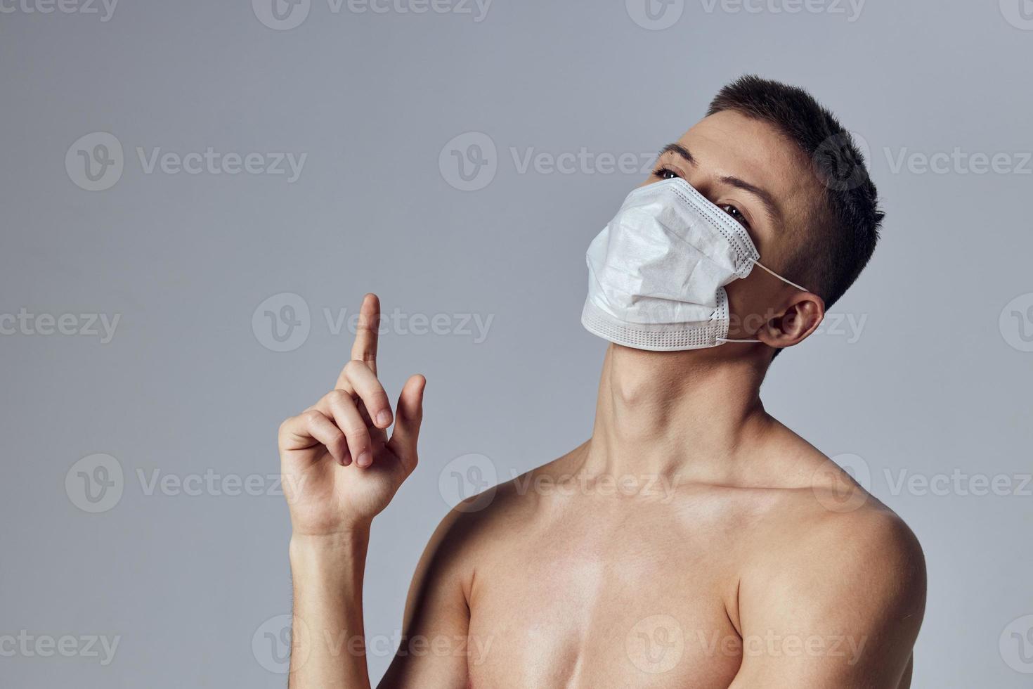 athletic man naked shoulders showing thumbs up medical mask posing photo
