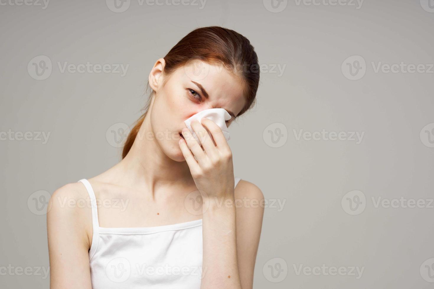 sick woman in white t-shirt with a scarf light background photo