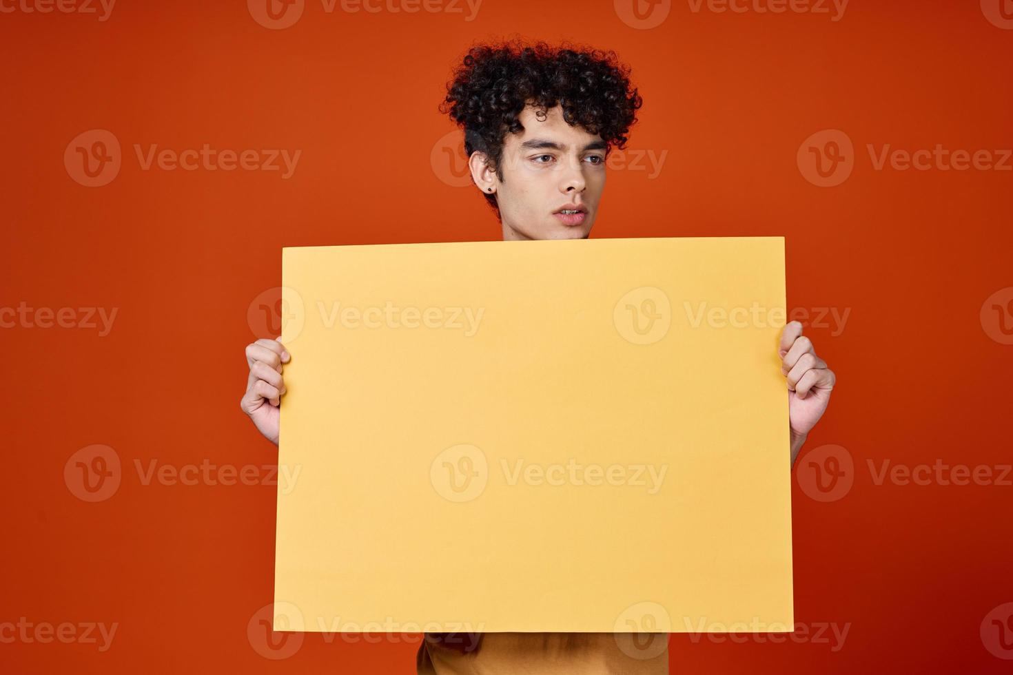 guy with curly hair yellow poster advertising red isolated background photo