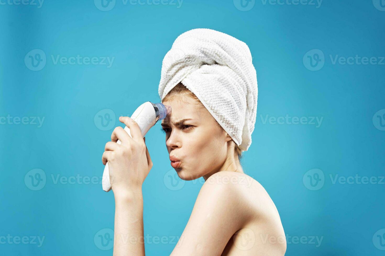 cheerful woman with a towel on her head massagers in hands dermatology clean skin photo