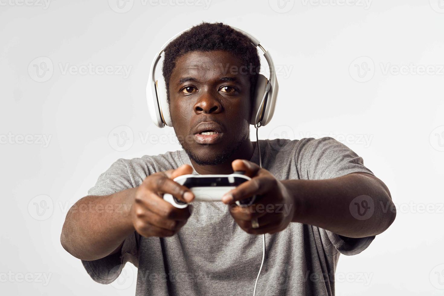 a man of african appearance in headphones with a gamepad in his hands plays video games technology photo
