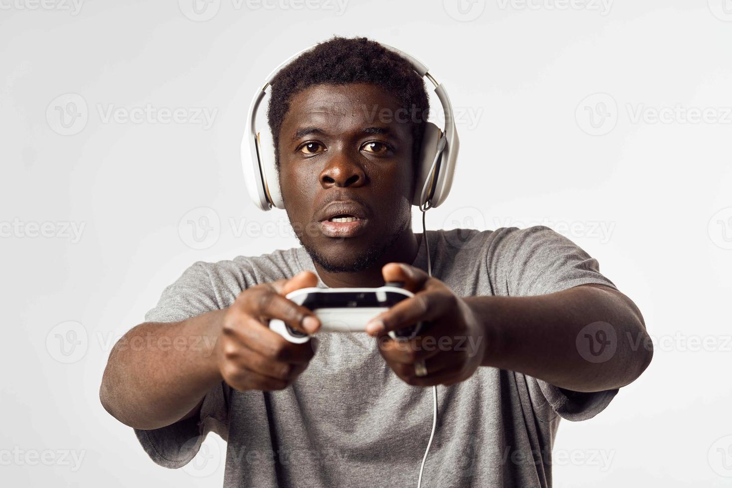 un hombre de africano apariencia en auriculares con un gamepad en su manos obras de teatro vídeo juegos tecnología foto