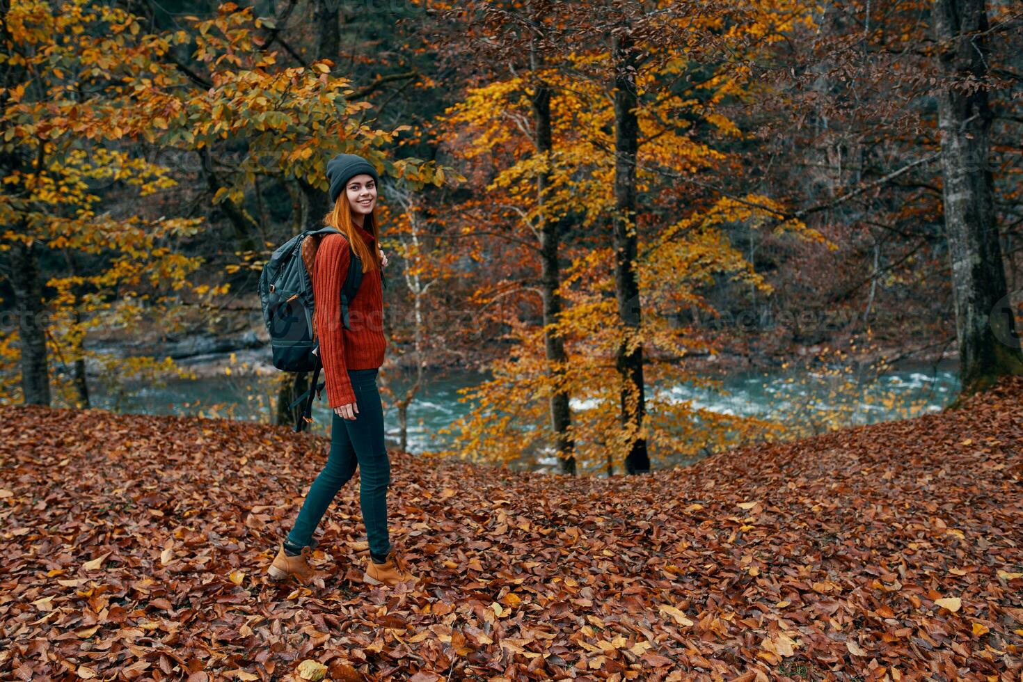 un viajero con un mochila camina en el parque en naturaleza cerca el río en otoño foto