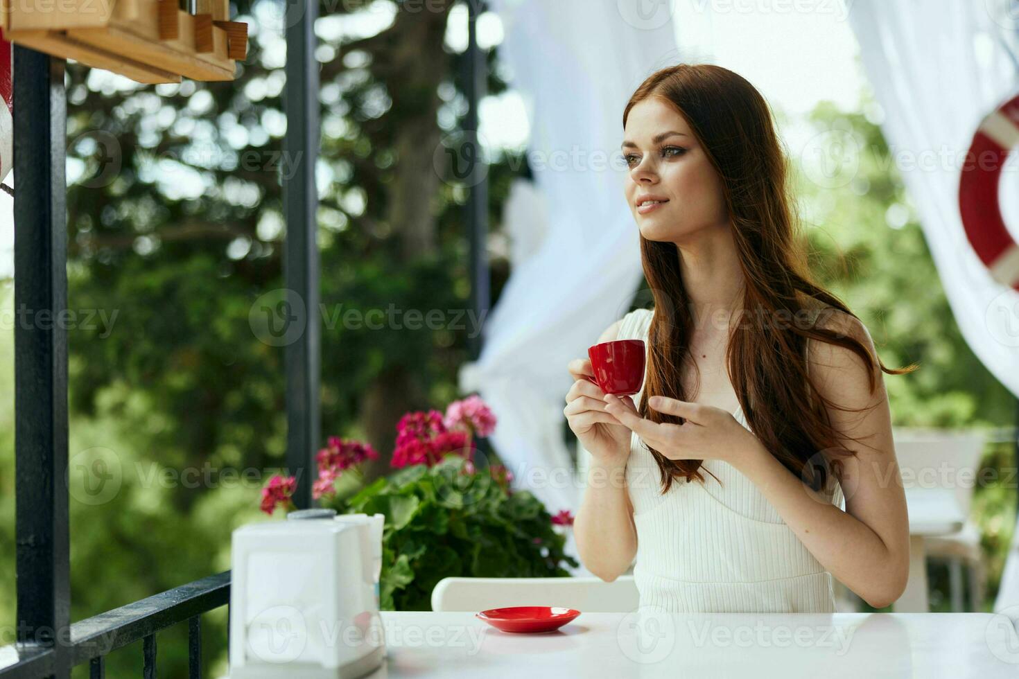 pretty woman in a white dress drinks coffee outdoors in a cafe Relaxation concept photo