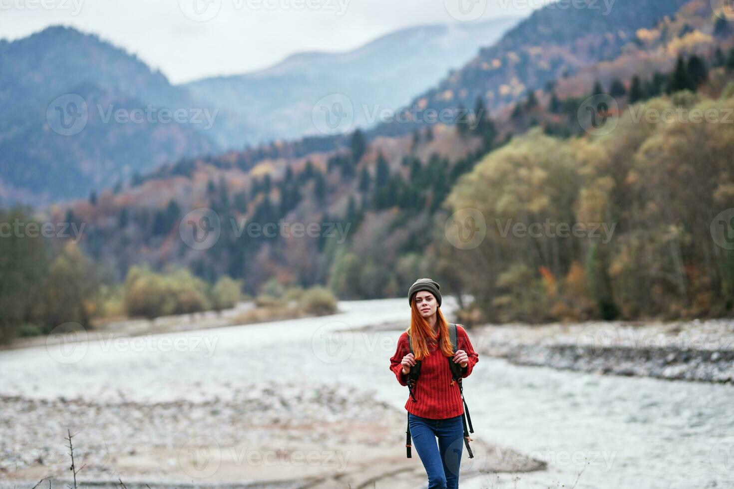 hiker with a backpack on the banks of the river in the mountains and landscape morning model tourism photo