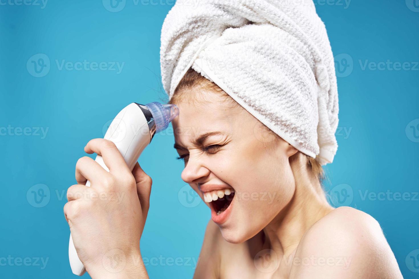 woman with towel on head cleaning face skin care blue background photo