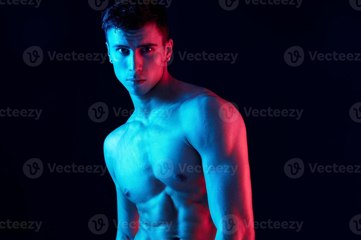 portrait of a young man with a pumped-up torso on a black background close-up cropped view photo