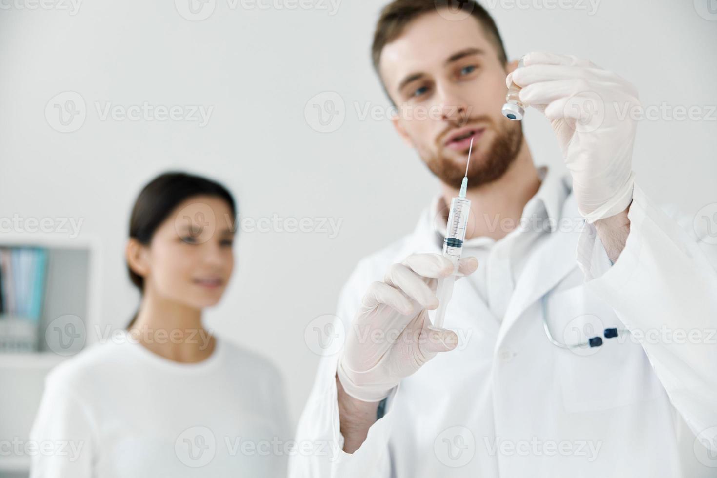 professional doctors with liquid in syringe and patient health covid-19 vaccine photo