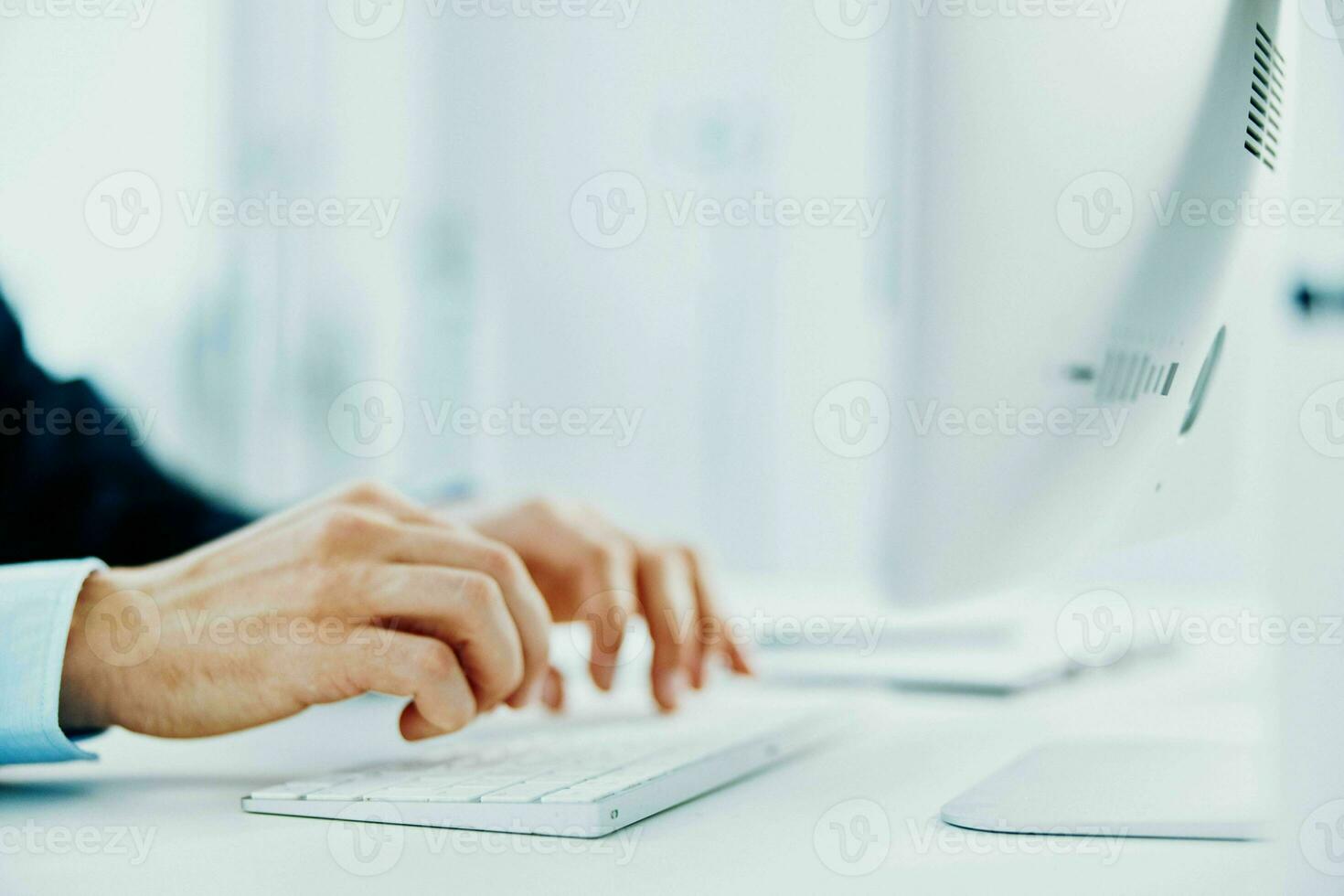 a man with a keyboard on a desktop office working at a computer photo
