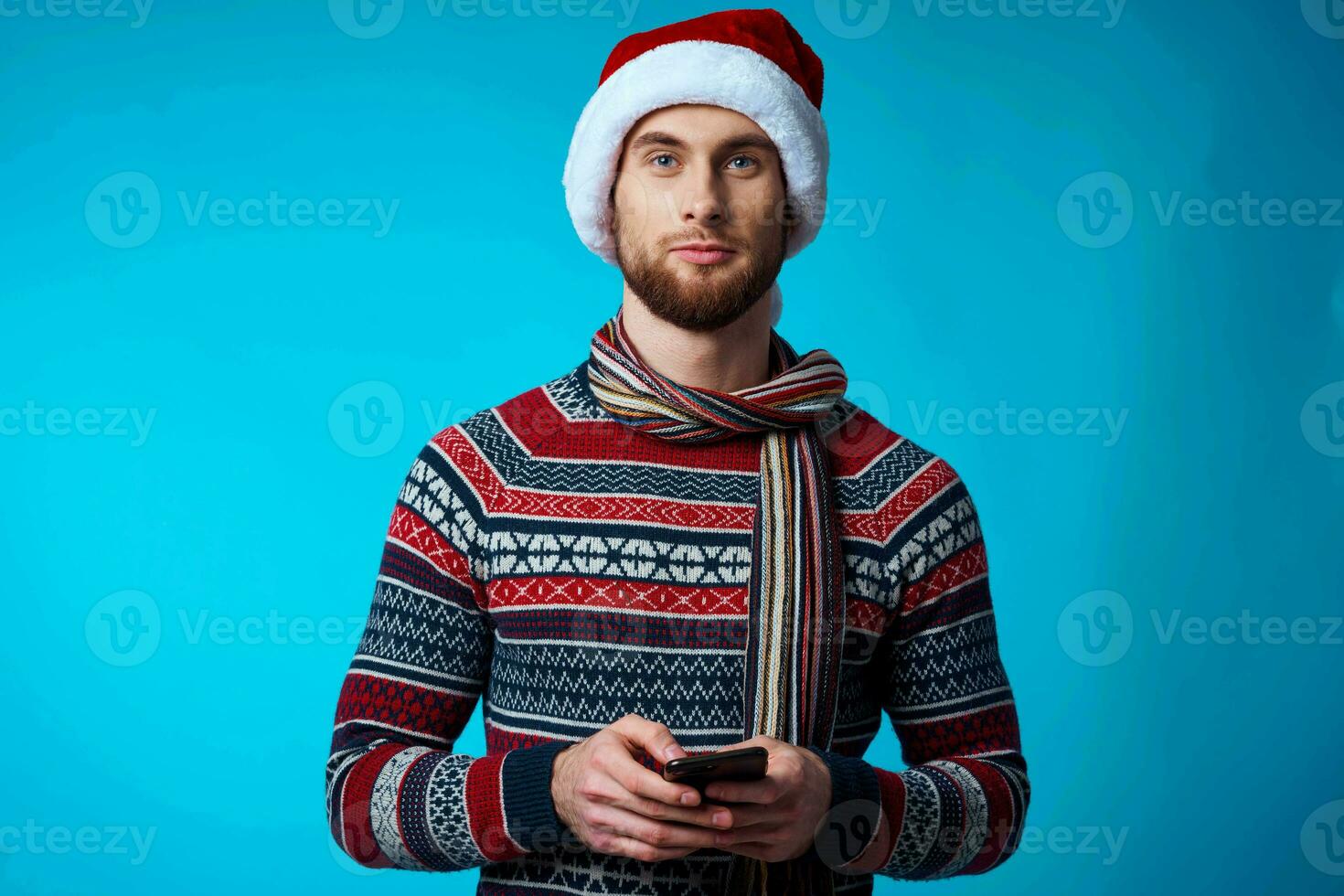 alegre hombre con un teléfono en mano fiesta Navidad tecnología azul antecedentes foto