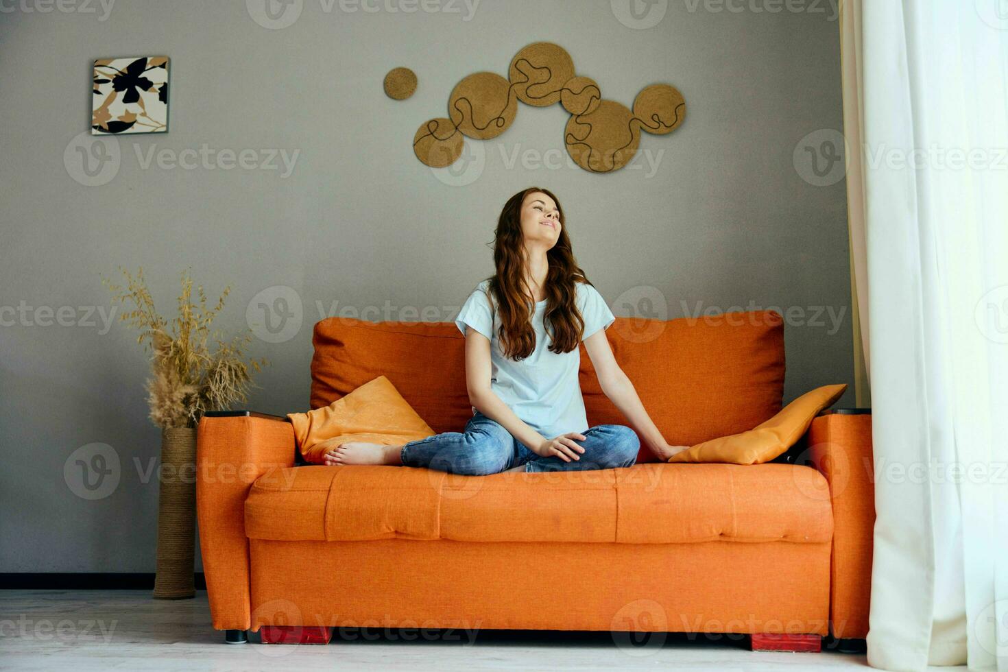 smiling woman on the orange couch in the rest room posing unaltered photo