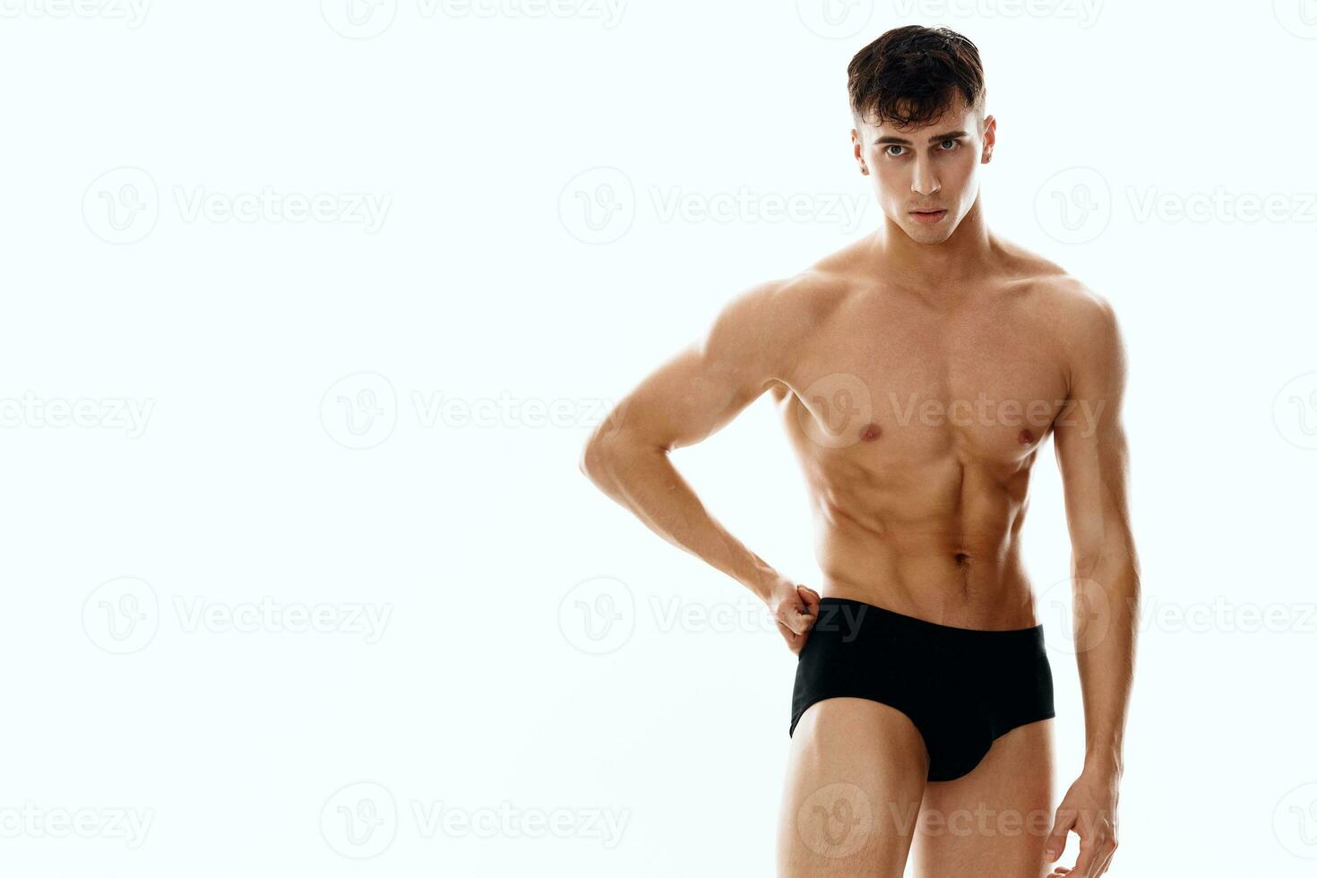 sexy guy athlete in shorts on a white background naked torso photo
