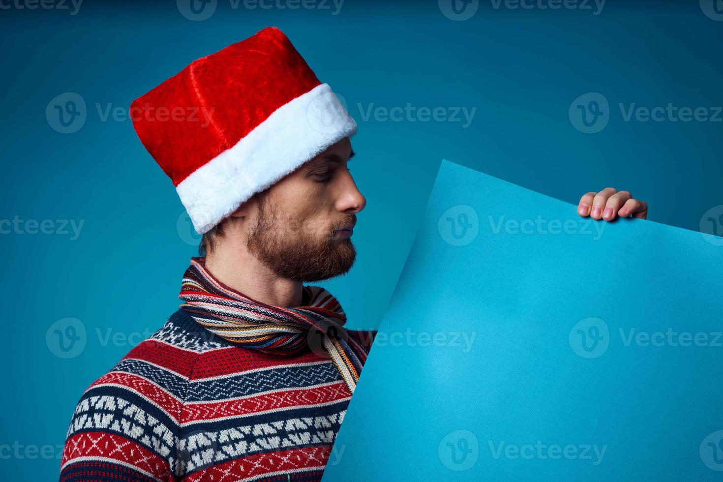 hermoso hombre en un Papa Noel sombrero participación un bandera fiesta estudio posando foto